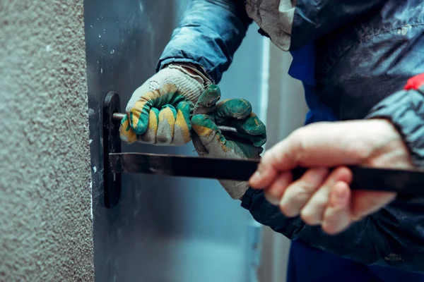 Hırsızlar ön metal kapıyı levye ve yankesicilerle kırıyorlar. Doğaçlama aletler. Eller yakın plan..