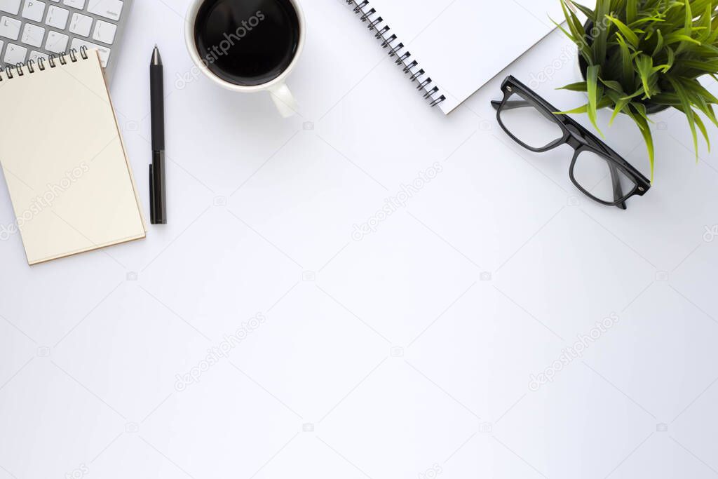 Top view above of White office desk table with keyboard, notebook and coffee cup with equipment other office supplies. Business and finance concept. Workplace, Flat lay with blank copy space.