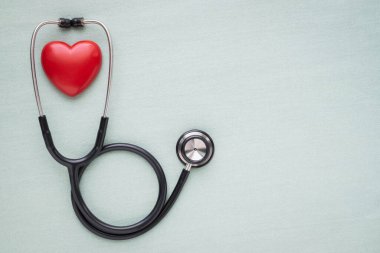 Açık yeşil arka planı kontrol etmek için kırmızı kalpli siyah steteskop. Stetoskop ekipmanları ses tanısı koymak için kullanılır. Kopyalı sağlık ve kardiyoloji kavramı.