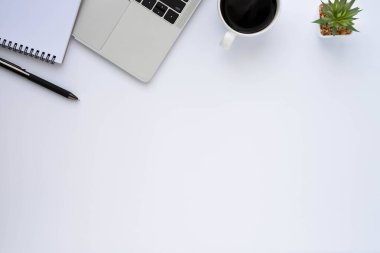 Beyaz ofis masasının üstünde klavye, defter ve kahve fincanı ve diğer ofis malzemeleri. İş ve finans kavramı. Çalışma yeri, boş kopya alanı olan düz uzanma.