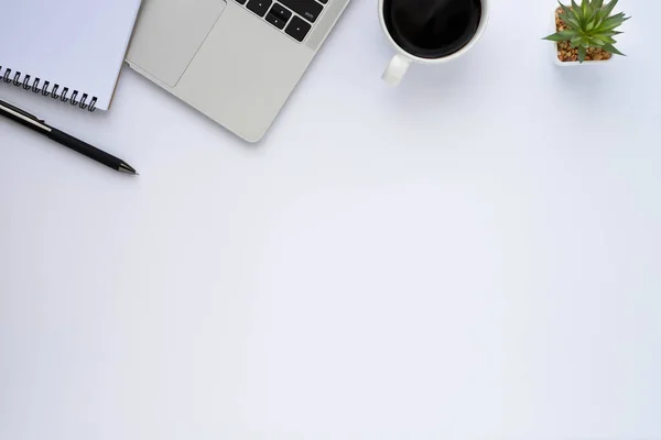 Top view above of White office desk table with keyboard, notebook and coffee cup with equipment other office supplies. Business and finance concept. Workplace, Flat lay with blank copy space.