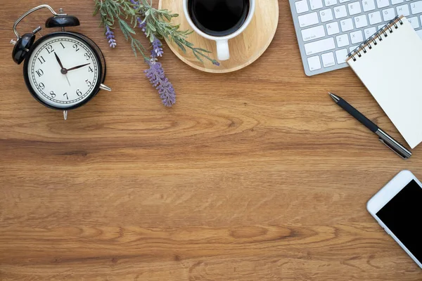 Top view above of Wooden office desk table with keyboard, coffee cup and notebook, phone with equipment office supplies. Business and finance concept. Workplace, Flat lay with blank copy space.