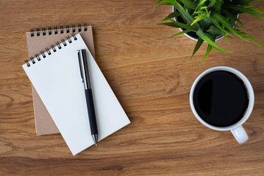 Boş sayfaları olan açık okul defterinin üst görüntüsü, masa arkasına not almak için kahve fincanı ve kalem. Düz yatış, yaratıcı çalışma alanı ofisi. Kopya alanı ile işletme eğitimi kavramı.