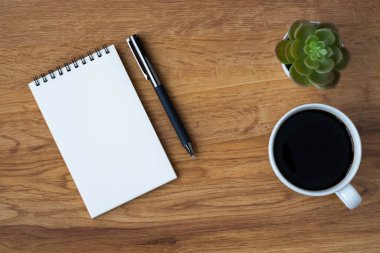 Boş sayfaları olan açık okul defterinin üst görüntüsü, masa arkasına not almak için kahve fincanı ve kalem. Düz yatış, yaratıcı çalışma alanı ofisi. Kopya alanı ile işletme eğitimi kavramı.