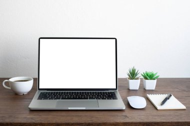 Laptop boş ekran, ahşap ofis masasında kahve fincanı ve defter, ekipman ofis malzemeleri olan fare bilgisayarı. İş ve finans kavramı. Çalışma yeri, kopyalama alanı olan düz uzanma.