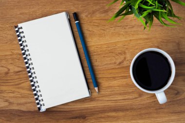 Boş sayfaları olan açık okul defterinin üst görüntüsü, masa arkasına not almak için kahve fincanı ve kalem. Düz yatış, yaratıcı çalışma alanı ofisi. Kopya alanı ile işletme eğitimi kavramı.