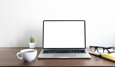 Laptop boş ekran, ahşap ofis masasında kahve fincanı ve defter, ekipman ofis malzemeleri olan fare bilgisayarı. İş ve finans kavramı. Çalışma yeri, kopyalama alanı olan düz uzanma.