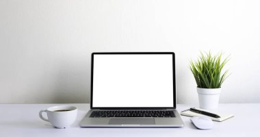 Laptop boş ekran beyaz ofis masasında kahve fincanı ve defter, ekipman ofis malzemeleri ile fare bilgisayarı. İş ve finans kavramı. Çalışma yeri, kopyalama alanı olan düz uzanma.