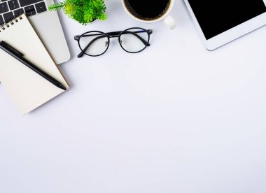 Üzerinde klavye, defter, kahve fincanı ve telefon olan beyaz ofis masasının üstü. İş ve finans kavramı. Çalışma yeri, boş kopya alanı olan düz uzanma.