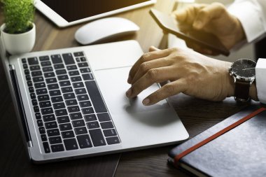 Ofis masasındaki dizüstü bilgisayarın klavyesini kullanarak erkek eli yakın çekim. Çalışma alanı, iş adamı, fotokopi alanı ile ilgili yaratıcı proje fikri. Yatırım finansmanı muhasebe kavramı.
