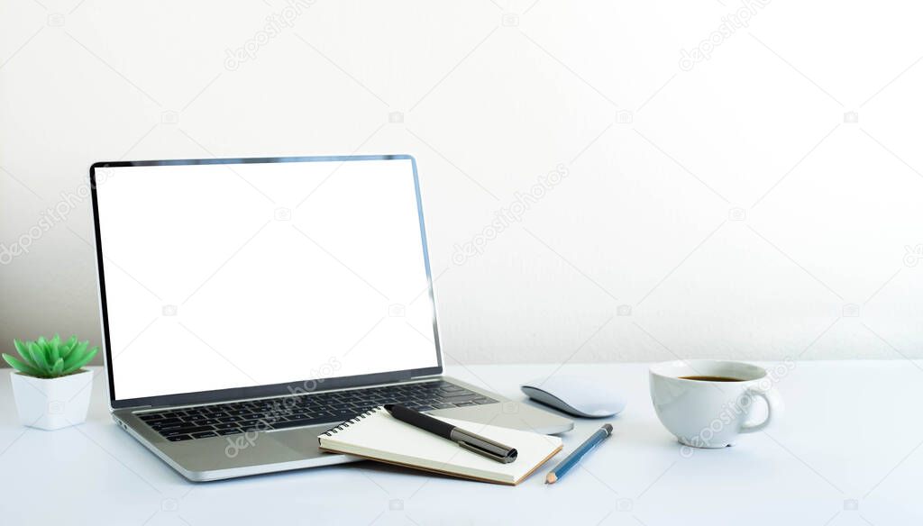Laptop computer blank screen on white office desk table with coffee cup and notebook, mouse computer with equipment office supplies. Business and finance concept. Workplace, Flat lay with copy space.