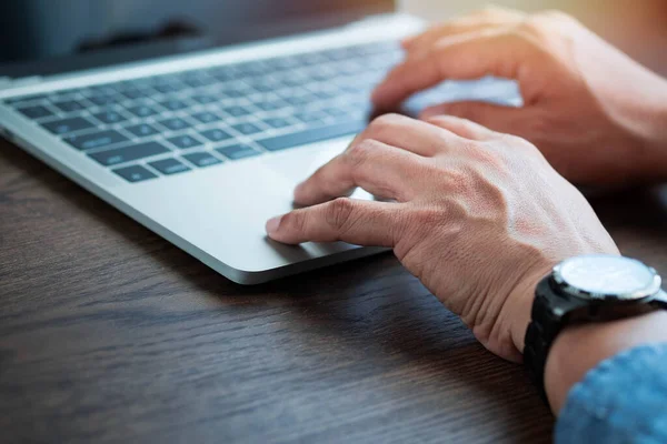 Close-up of man hands using and typing keyboard of laptop computer on office desk. Workspace, businessman working project creative idea for job online network. Business finance and technology concept.