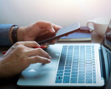 Ofis masasında dizüstü bilgisayarın klavyesini kullanan ve daktilo eden erkek ellerine yakın çekim. Çalışma alanı, iş adamı proje yaratıcı fikri çevrimiçi iş ağı. İş finans ve teknoloji kavramı.