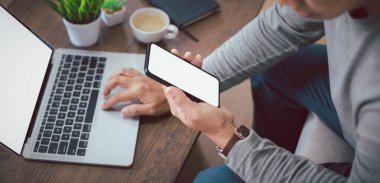 Adamın elini kullanırken, akıllı telefonu tutarken ya da boş beyaz ekranlı cep telefonu modeli çekilirken. Telefon teknolojisi ve dijital modern tasarım kopyalama alanı ile dokunmatik ekran kullanabilir.