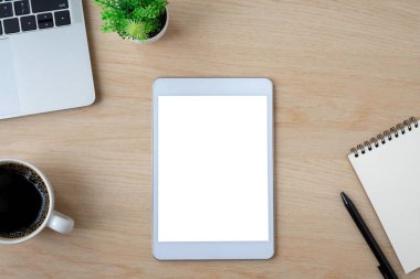 Tablet boş ekranın üstündeki beyaz ekran tahta ofis masasında dizüstü bilgisayarlı, defterli. Çalışma alanı, ofis iş teknolojisi. Eğitim ve iş konsepti. düz yat