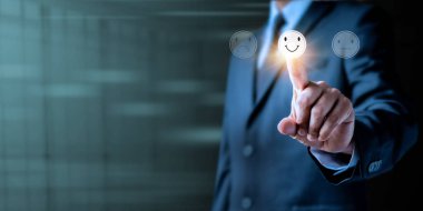 Müşteri hizmetleri ve Deneyim Tatmin Değerlendirme Konsepti. İş adamı eli görüntüsü, sanal ekranda gülen yüz duygusunu seçiyor. En iyi hizmet derecelendirme istemcisi.