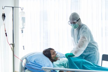 Koruyucu giysili doktorlar CORONA VISRUS veya COVID-19 enfeksiyonlu hastalara bakıyorlar. Hastanedeki karantina odasında..