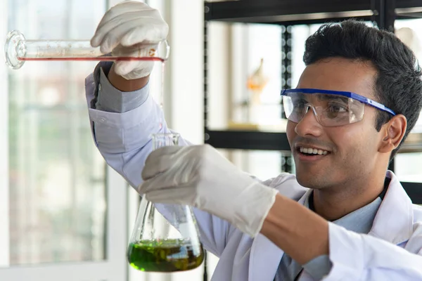 Young scientist or researcher wear eye glasses doing chemical research in laboratory. Scientist working on laboratory equipment.