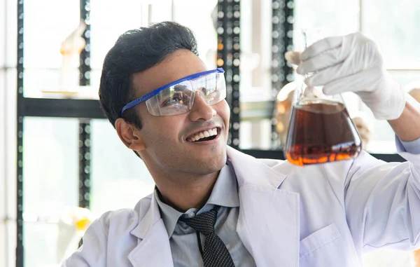 Young scientist or researcher wear eye glasses doing chemical research in laboratory. Successful scientist working on laboratory equipment discover new drug and vaccine