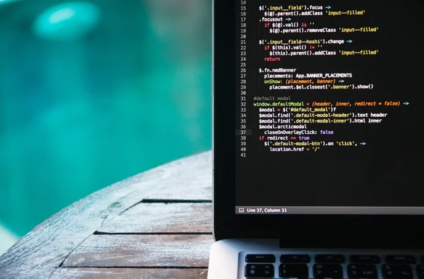 Laptop auf Holztisch vor dem Hintergrund des Swimmingpools — Stockfoto