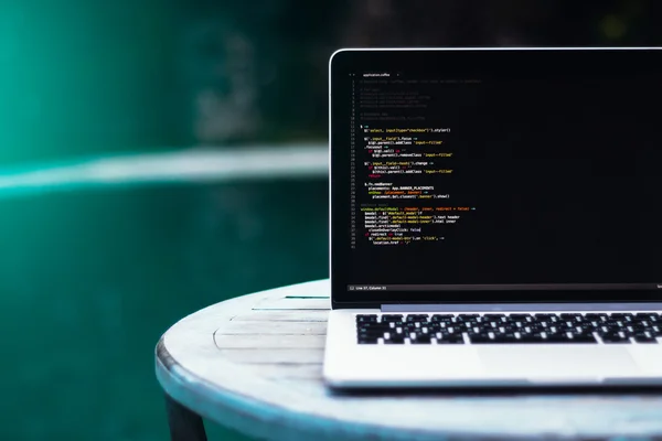 Laptop auf Holztisch vor dem Hintergrund des Swimmingpools — Stockfoto