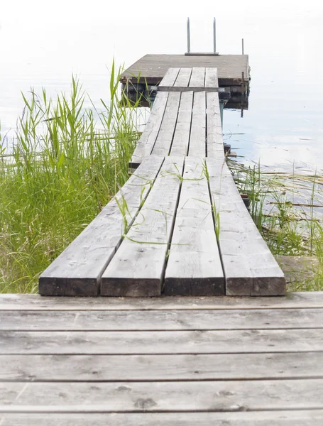 Wooden boardwalk leading out to raft or float — Stock Photo, Image