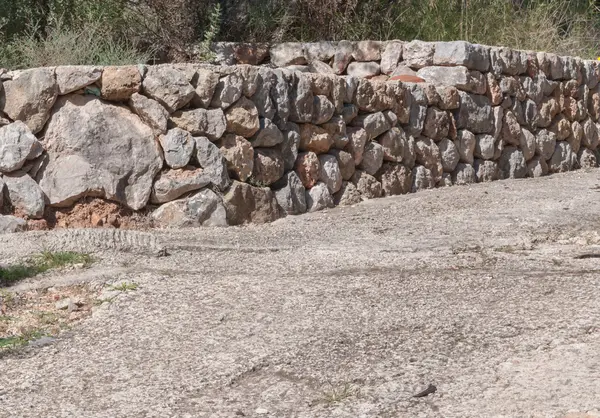 Nahaufnahme einer Trockenmauer entlang einer Landstraße — Stockfoto