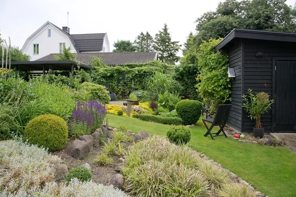 Green lawn and flowerbed. — Stock Photo, Image