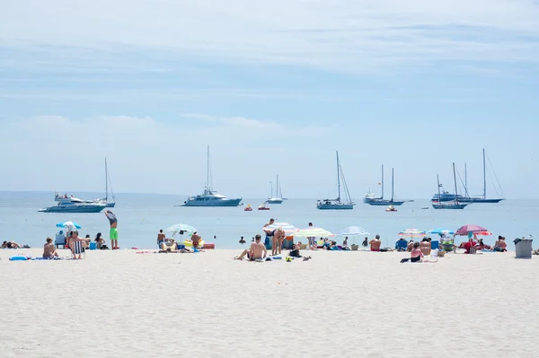 Strand scène met toeristen en zonaanbidders — Stockfoto