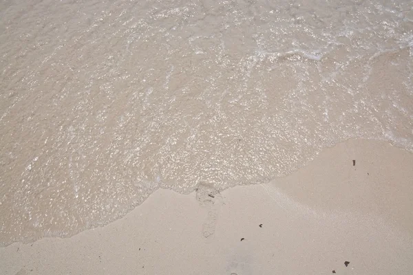 Praia de areia com pegada na água — Fotografia de Stock
