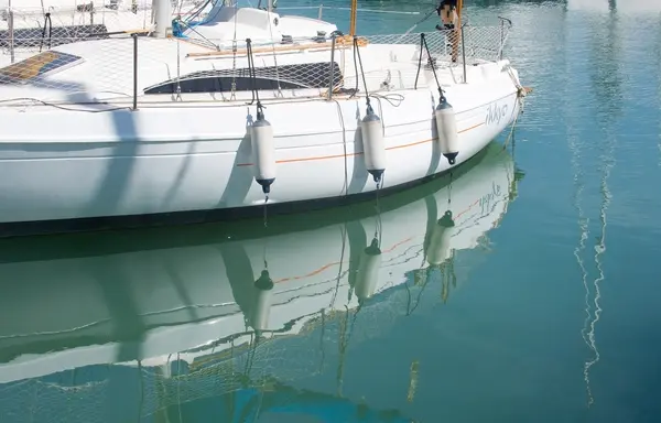 Barco blanco amarrado en agua verde con reflejos —  Fotos de Stock