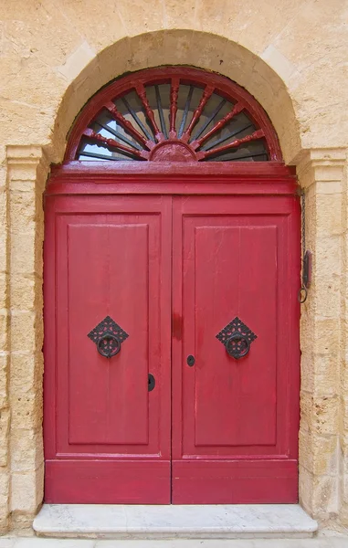 Red door with black iron knobs — Stock Photo, Image