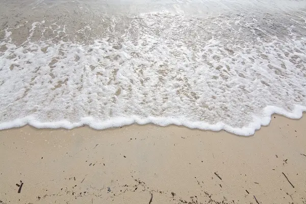 Foamy wave on sandy beach — Stock Photo, Image