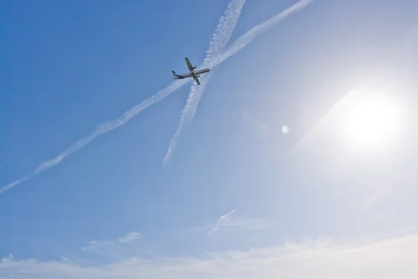 Avión en el cielo brumoso con senderos — Foto de Stock