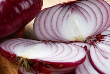 Cut juicy salad onions on a wooden board close-up.