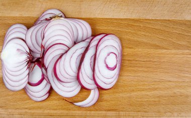 A juicy onion cut into rings on a wooden board. wooden background.