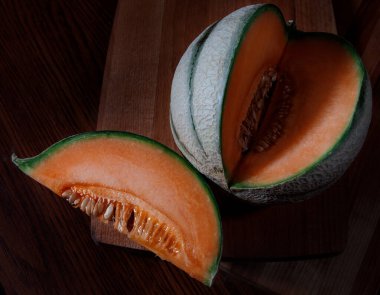 Tahtada bir parça kavun ve olgun bir kavun..