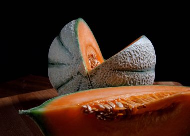 Ahşap bir tahtanın üzerinde olgun, lezzetli bir kavun. Güzel sulu kavun.