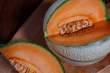 Tahtada bir parça kavun ve olgun bir kavun..