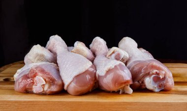 Çiğ tavuk bacakları tahta kesme tahtasına dizilir..