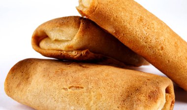 Beyaz arka planda süzme peynirle doldurulmuş krepler..