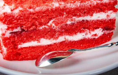 Beyaz tabakta gümüş kaşıkla güzel bir pasta..