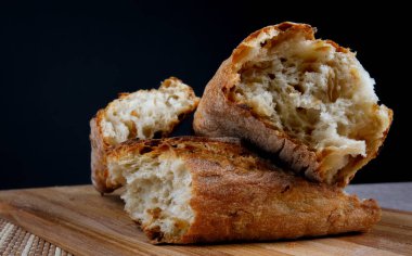 Tahta kesme tahtasının üzerinde kırılmış ekmek. Ekmeği yakından çek. Sanat ekmeği.