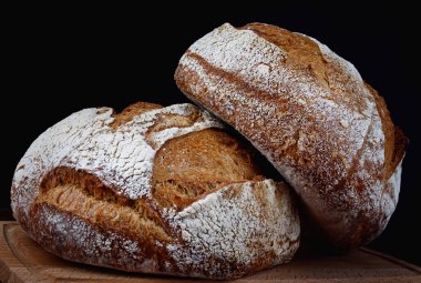 Tahta üzerinde iki somun rustik ekmek. Ev yapımı ekmek. .