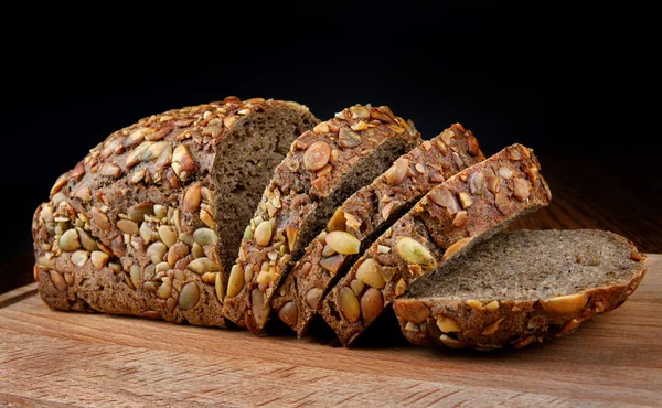 Bread with pumpkin seeds on a wooden board.