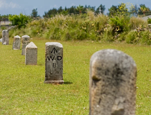 A row of stone, nautical mile markers against green grass — Stock Photo, Image