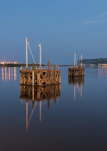 Dos embarcaderos de madera reflejándose en las tranquilas aguas de la bahía de Cardiff — Foto de Stock