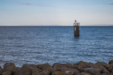 Bristol kanalında, Cardiff Körfezi 'nin hemen dışında tek bir rehber direğinin görüntüsü. Martılar direğe tünemiş.. 