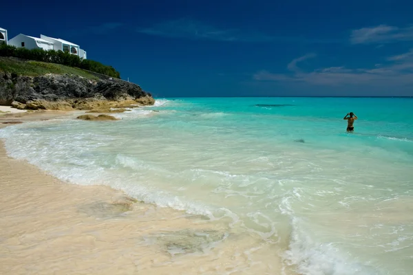 Uma praia tropical, com uma única mulher no mar — Fotografia de Stock