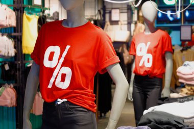 Mağazadaki kırmızı tişörtlü, yüzde yüz sembollü iki manken. Satış indirimi kavramı.